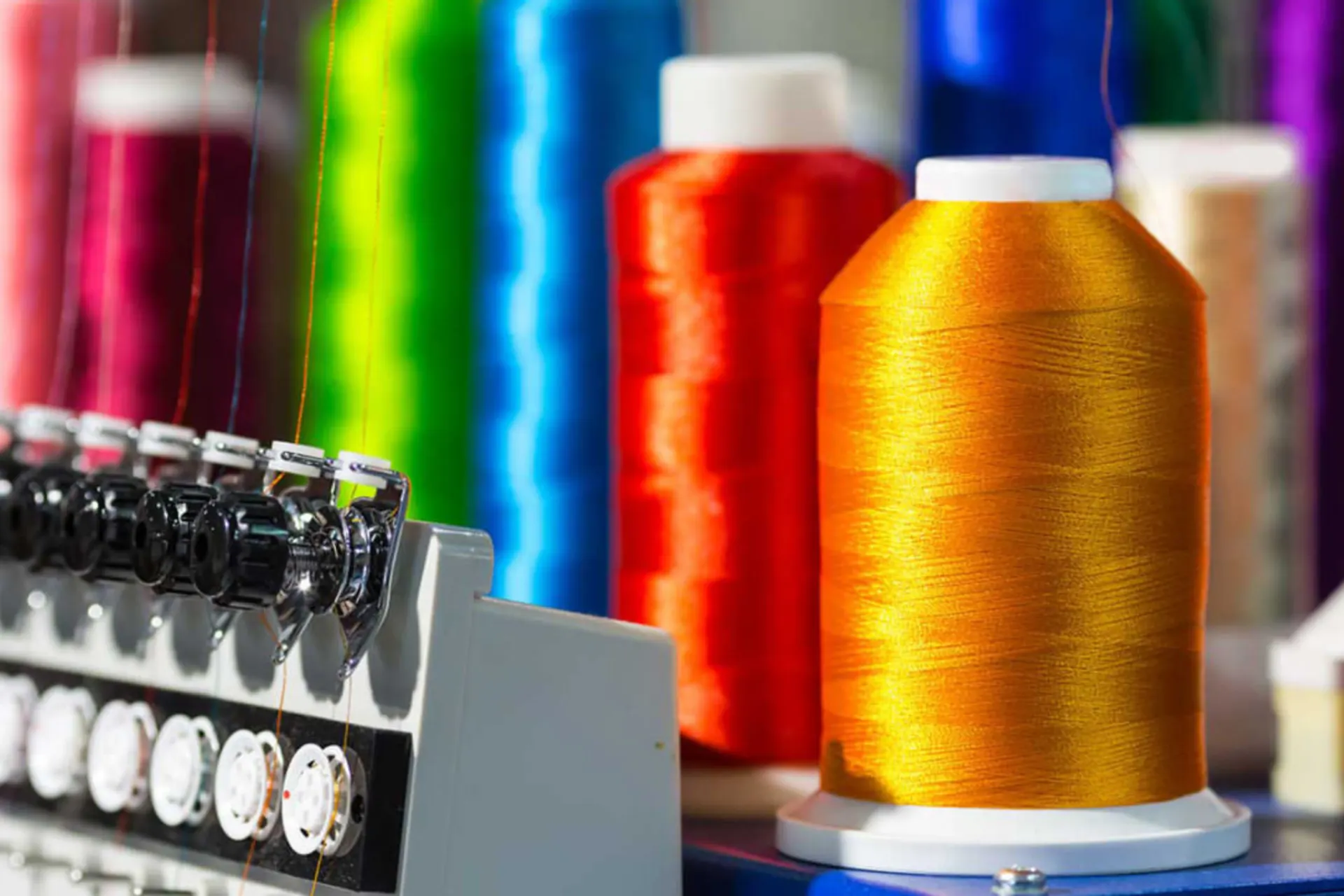 spools of multicolored thread connected to an embroidery machine